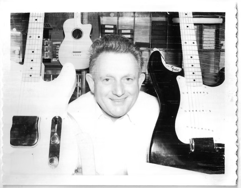 Amos Arthur surrounded by guitars at Arthur’s Music Store in Indianapolis, circa 1954.
