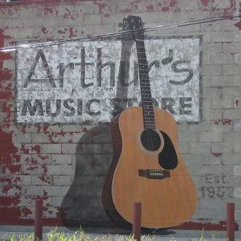 The north wall mural at Arthur’s Music Store in 2006, featuring a large painted acoustic guitar beside the store’s name.