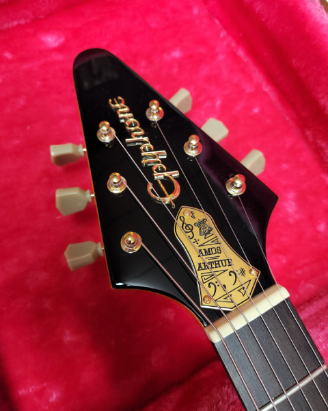 Headstock detail of the Epiphone Limited Edition Joe Bonamassa “Amos” 1958 Flying V, featuring a decorative truss rod cover honoring Amos Arthur.