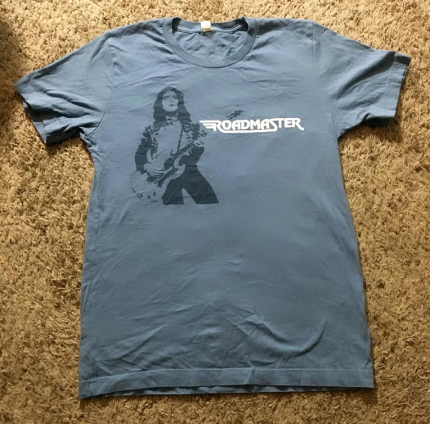 The front of a Ricky Benick tribute T-shirt features the Roadmaster guitarist in concert alongside the band’s logo. Photo courtesy of John Brian.