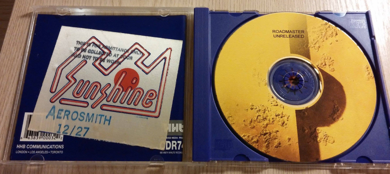 Sunshine backstage pass for the December 27, 1979, Aerosmith concert with special guest Roadmaster, displayed alongside a Roadmaster “Unreleased” CD. Photo courtesy of Jim Cuozzo Burnett.